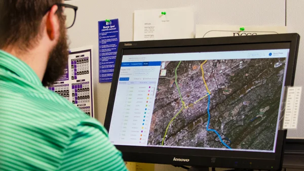 Employee sitting at desk looking at computer Screen